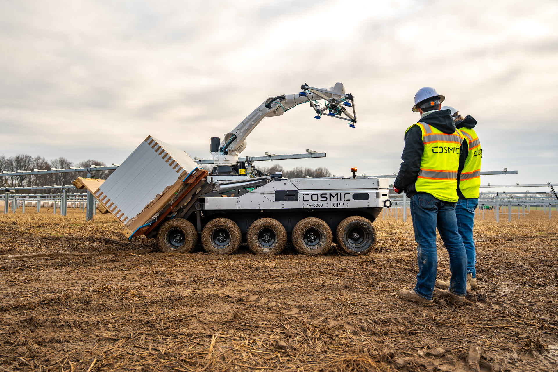 Cosmic Robotics solar-installation equipment beside a crew member in a field